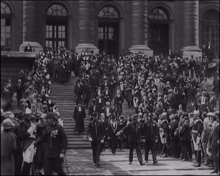 Film d’archives : des avocats en robe descendent les marches du Palais de Justice dans les années 1920.